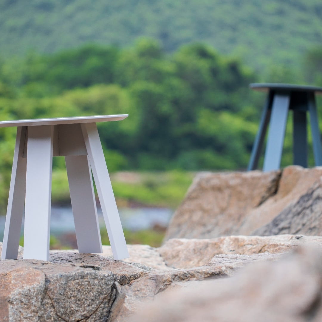 Placed on rocks , 2 small Full Moon Centre Table, a round wooden coffee and centre table you can buy online at Sukham Home, a sustainable furniture, kitchen & dining and home decor store in Kolkata, India