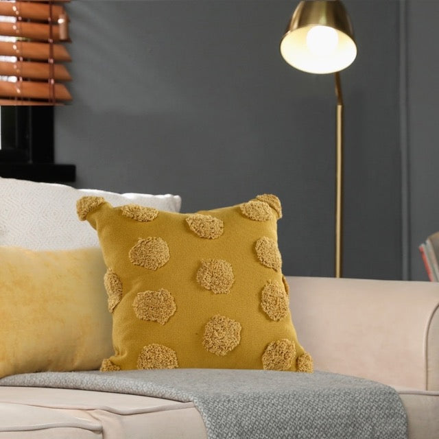 Arranged on a cream sofa, the Gold Tufted Dots Cushion, a square yellow accent pillow available at Sukham Home, a sustainable furniture, kitchen & dining and home decor store in Kolkata, India