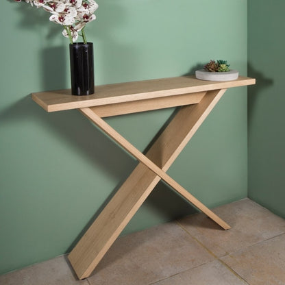 Against a green wall, the Oak Natural Greet, a wooden entryway console you can buy online at Sukham Home, a sustainable furniture, kitchen & dining and home decor store in Kolkata, India