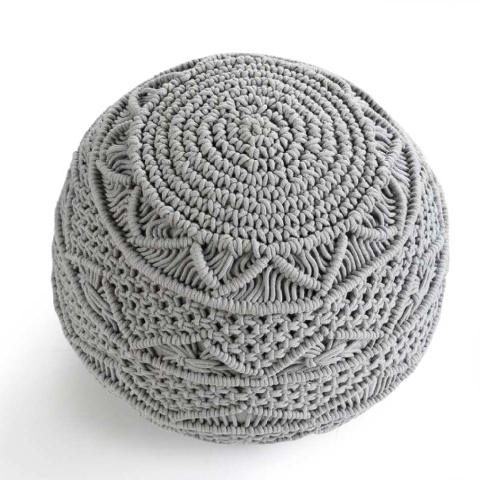 Against a white background, tilted view of the Grey Macrame Pouf, a grey ottoman made from cotton, available at Sukham Home, a sustainable furniture, kitchen & dining and home decor store in Kolkata, India