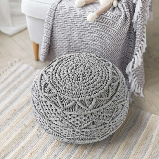 Placed on a rug, the Grey Macrame Pouf, a grey ottoman made from cotton, available at Sukham Home, a sustainable furniture, kitchen & dining and home decor store in Kolkata, India