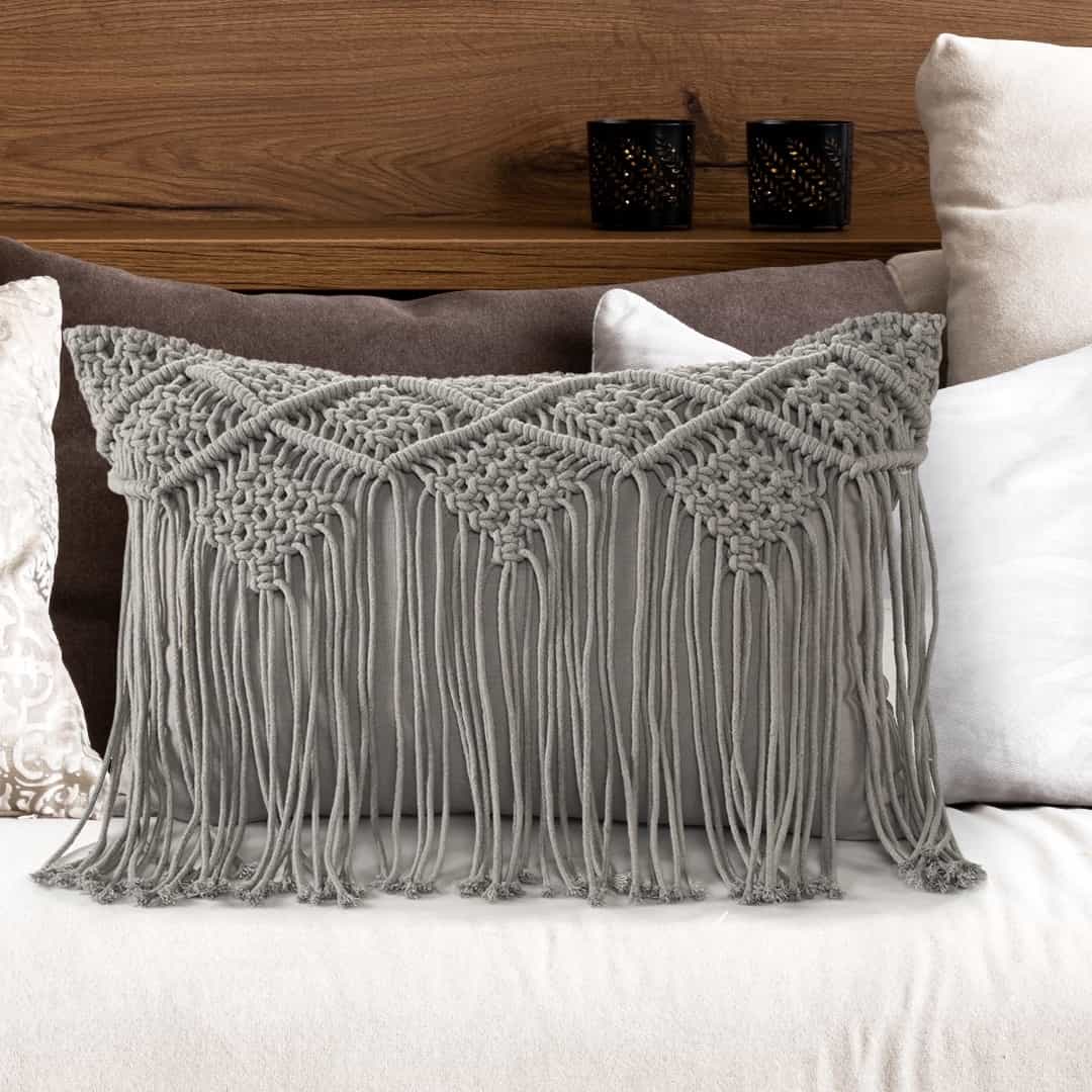 Arranged in a room, the Grey Macrame Cushion with Fringes, a rectangle accent pillow you can buy online at Sukham Home, a sustainable furniture, kitchen & dining and home decor store in Kolkata, India