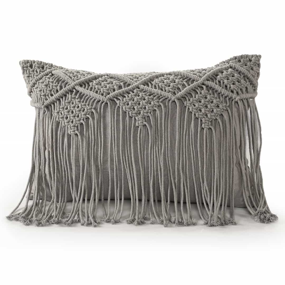 Against a white background, the Grey Macrame Cushion with Fringes, a rectangle accent pillow you can buy online at Sukham Home, a sustainable furniture, kitchen & dining and home decor store in Kolkata, India