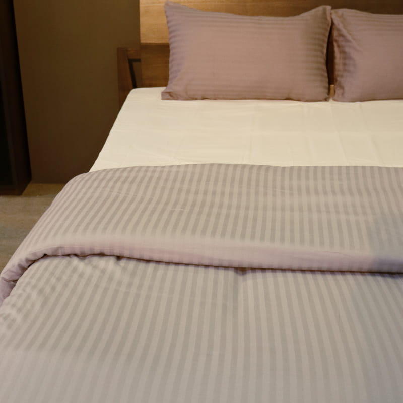 One pillow cover and duvet of the Grey Striped Egyptian Cotton Duvet Cover, a silver king size duvet cover you can buy online at Sukham Home, a sustainable furniture, gardening and home decor store in Kolkata, India