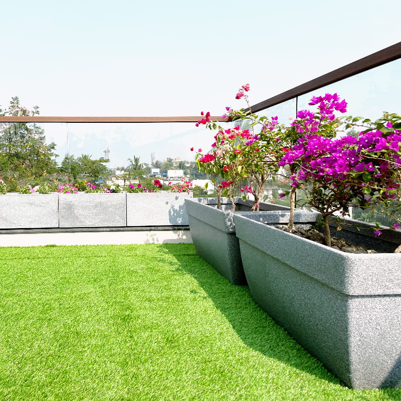 On a rooftop terrace, the Grey Stone Barca Rectangle, a rectangle stone finish plastic planter that looks like granite available at Sukham Home, a sustainable furniture, gardening and home decor store in Kolkata, India