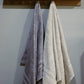 Hanging bath towels from the Grey & Beige Silly-Cuddly, a set of 8 floral embroidered towels you can buy online at Sukham Home, a sustainable furniture, kitchen & dining and home decor store in Kolkata, India