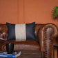 Placed on a tan brown sofa, the Hailey Cushion, a black leatherette cotton handpainted rectangle accent pillow you can buy online at Sukham Home, a sustainable furniture, kitchen & dining and home decor store in Kolkata, India