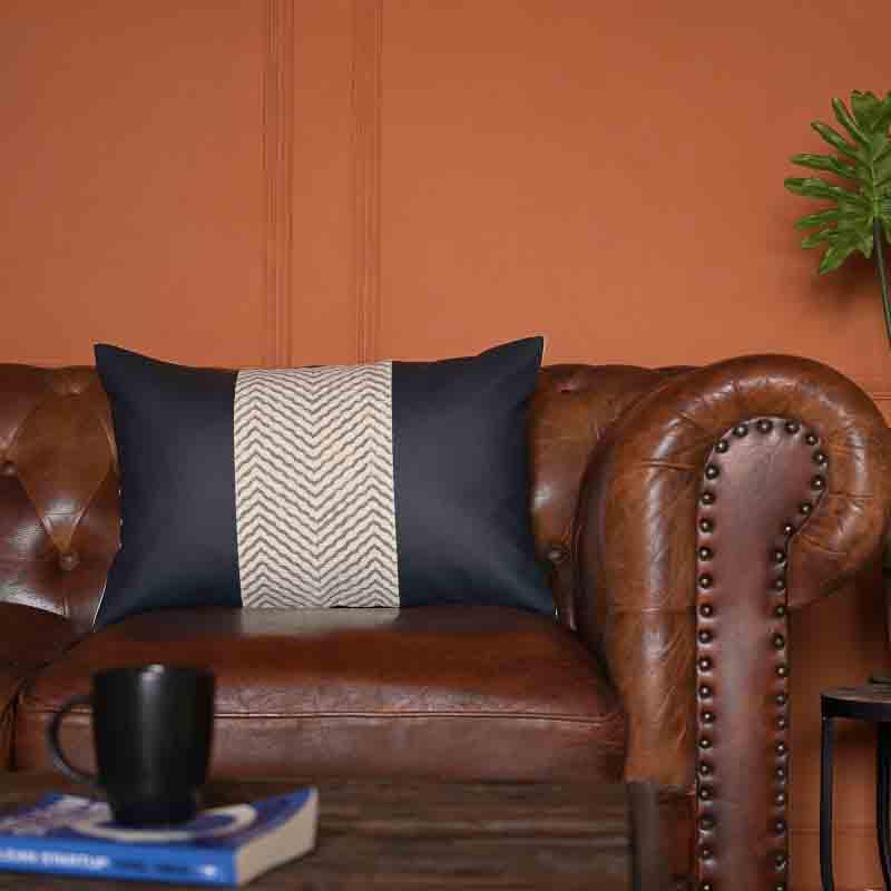 Placed on a tan brown sofa, the Hailey Cushion, a black leatherette cotton handpainted rectangle accent pillow you can buy online at Sukham Home, a sustainable furniture, kitchen & dining and home decor store in Kolkata, India