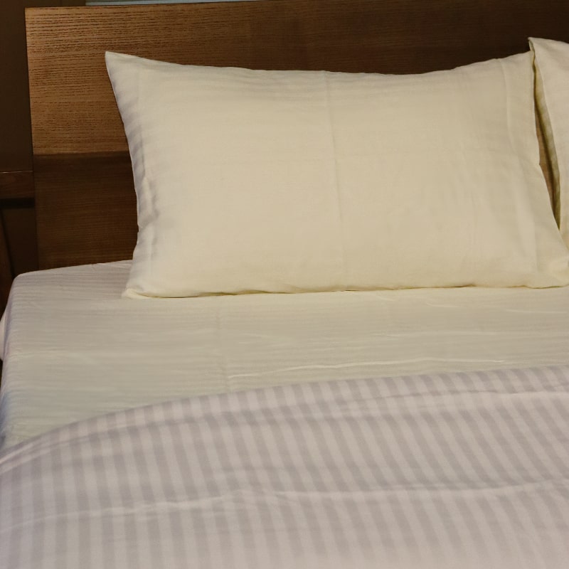 Side angle of the Ivory Sateen Striped Bedsheet, a cream king and queen size cotton bedsheet you can buy online at Sukham Home, a sustainable furniture, gardening and home decor store in Kolkata, India