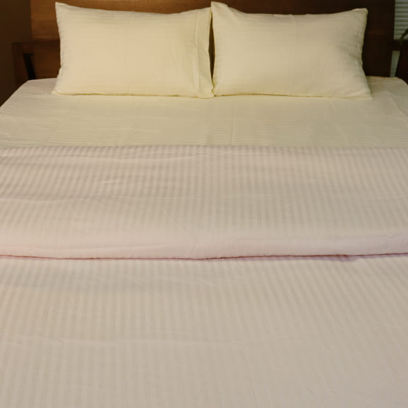 Both pillow covers and duvet of the Ivory Striped Egyptian Cotton Duvet Cover, a white king size duvet cover you can buy online at Sukham Home, a sustainable furniture, gardening and home decor store in Kolkata, India