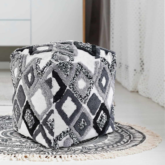 Placed on a rug, the Ivory White and Black Diamond Tufted Pouf, an ottoman made from cotton, available at Sukham Home, a sustainable furniture, kitchen & dining and home decor store in Kolkata, India