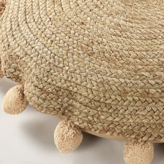 Close up of the pom poms on the Jute Round Floor Cushion, a circular braided accent pillow with pom poms, available at Sukham Home, a sustainable furniture, kitchen & dining and home decor store in Kolkata, India