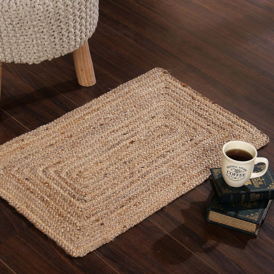 On a wooden floor, the Jute Braided Rug, a small rectangle jute carpet you can buy online at Sukham Home, a sustainable furniture, kitchen & dining and home decor store in Kolkata, India