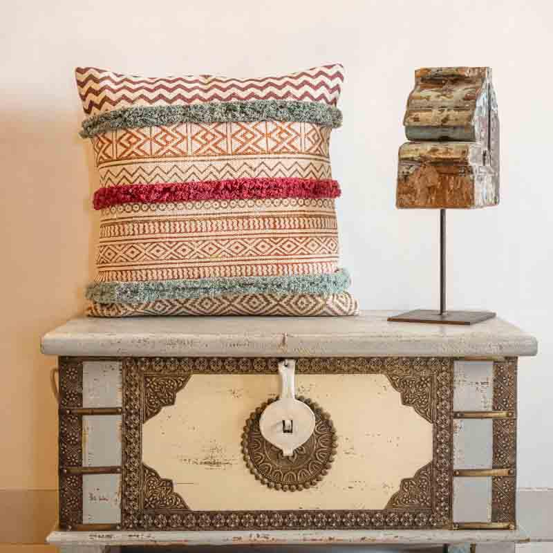 Placed on a chest the La La Land Cushion, a cotton handpainted and tufted accent pillow you can buy online at Sukham Home, a sustainable furniture, kitchen & dining and home decor store in Kolkata, India