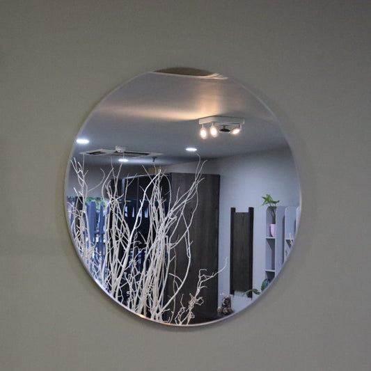 Against a grey background, the small Luna, a frameless round mirror you can buy online at Sukham Home, a sustainable furniture, kitchen & dining and home decor store in Kolkata, India