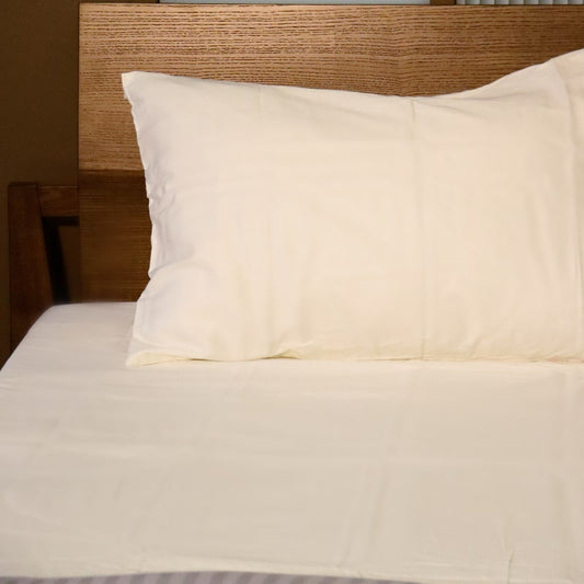 One pillowcase and bedsheet of the Moon White Classic Solid Bedsheet, a cream king size and queen size cotton bedsheet you can buy online at Sukham Home, a sustainable furniture, gardening and home decor store in Kolkata, India