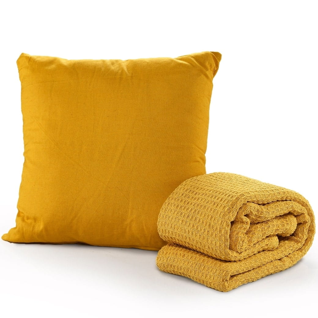 Against a white background, the whole set of the Mustard Waffle Cotton Throw with Cushion Cover, a yellow throw and cover set you can buy online at Sukham Home, a sustainable furniture, kitchen & dining and home decor store in Kolkata, India