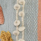 Close up of the tufting pattern on the Pastel Hued Abstract Cushion, a rectangle peach, blue, white and yellow accent pillow available at Sukham Home, a sustainable furniture, kitchen & dining and home decor store in Kolkata, India