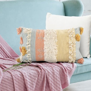 Arranged on a blue sofa, the Pastel Hued Abstract Cushion, a rectangle peach, blue, white and yellow accent pillow available at Sukham Home, a sustainable furniture, kitchen & dining and home decor store in Kolkata, India