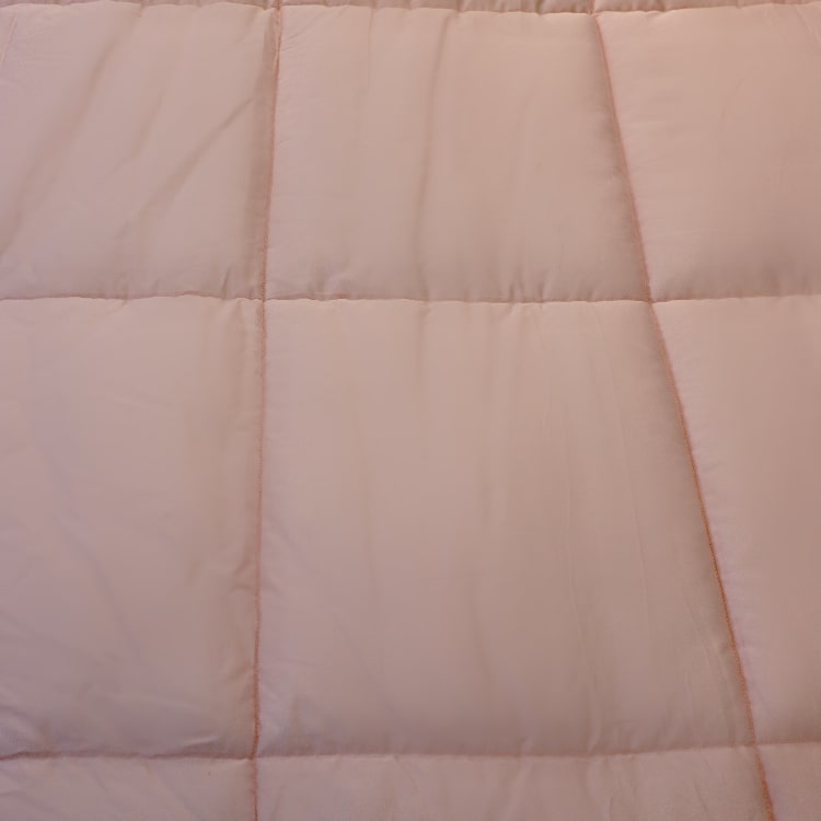 Close up of the texture and fabric of the Pink Solid Comforter, a pink king size cotton bedsheet you can buy online at Sukham Home, a sustainable furniture, gardening and home decor store in Kolkata, India