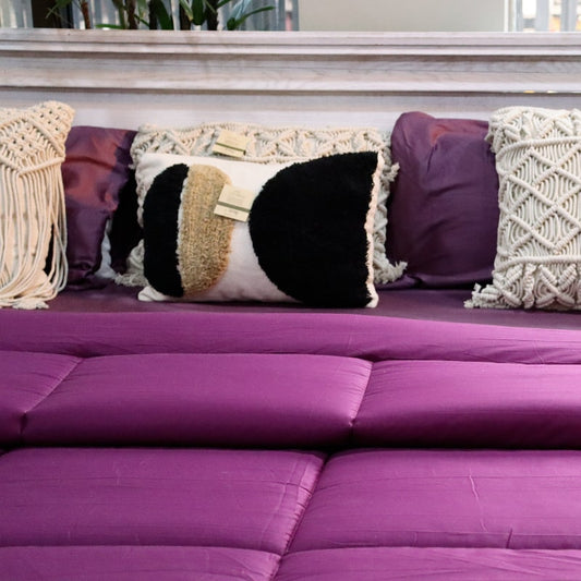 Placed on a bed, the Plum Solid Comforter, a purple king size cotton bedsheet you can buy online at Sukham Home, a sustainable furniture, gardening and home decor store in Kolkata, India
