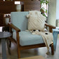 Using Snow blue fabric, the Oak Antique Poise Armchair, a wooden cushioned midcentury seat you can buy online at Sukham Home, a sustainable furniture, kitchen & dining and home decor store in Kolkata, India
