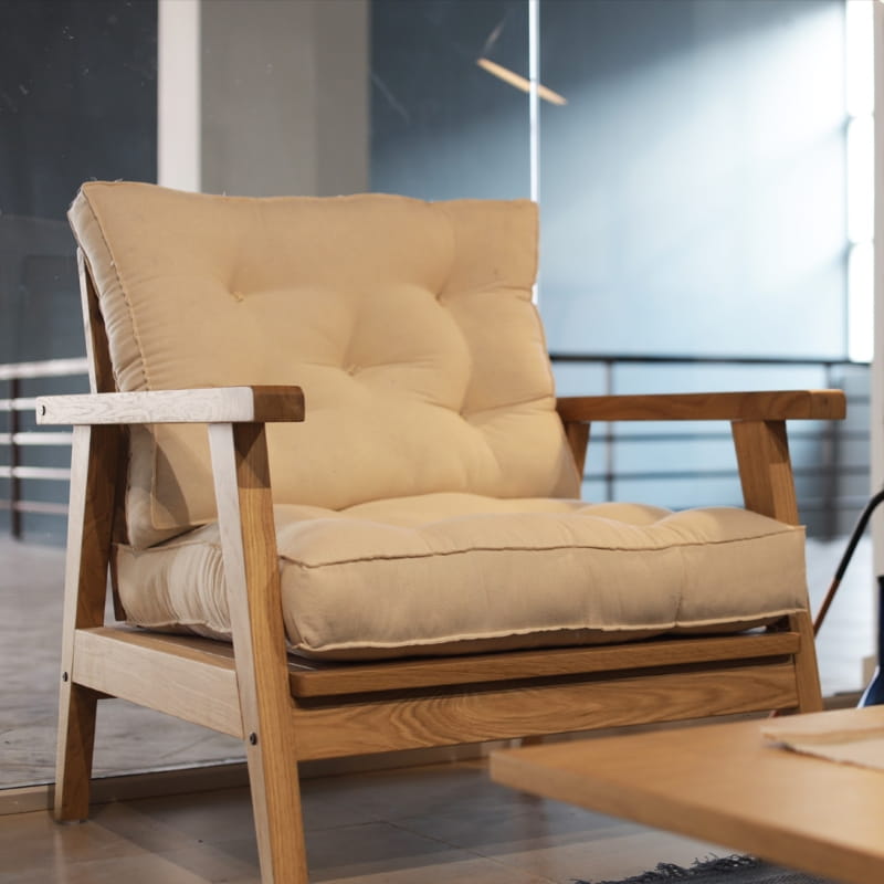 Using the Umber fabric, the Oak Natural Poise Armchair, a wooden cushioned midcentury seat you can buy online at Sukham Home, a sustainable furniture, kitchen & dining and home decor store in Kolkata, India