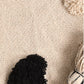Close up of the woven fabric of the Monochromatic Polka Dot Throw, a black and white throw you can buy online at Sukham Home, a sustainable furniture, kitchen & dining and home decor store in Kolkata, India