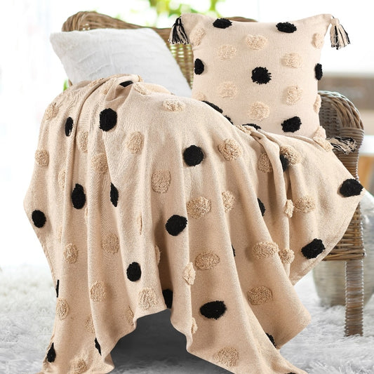 Placed on a chair, the Monochromatic Polka Dot Throw, a black and white throw you can buy online at Sukham Home, a sustainable furniture, kitchen & dining and home decor store in Kolkata, India