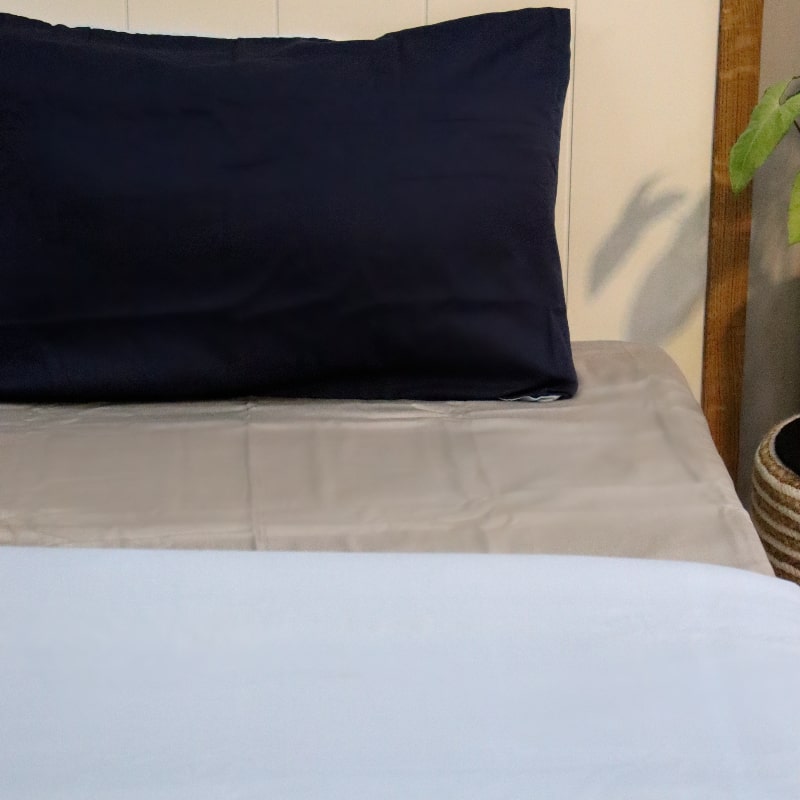 One navy blue pillow cover and sky blue duvet cover side of the Navy Blue-Sky Blue Reversible Egyptian Cotton Duvet Cover, a dual king size duvet cover you can buy online at Sukham Home, a sustainable furniture, gardening and home decor store in Kolkata, India