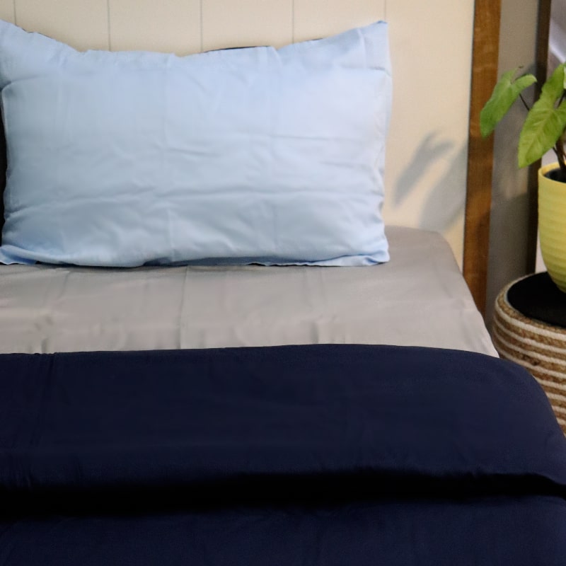 One sky blue pillow case and navy blue duvet cover of the Navy Blue-Sky Blue Reversible Egyptian Cotton Duvet Cover, a dual king size duvet cover you can buy online at Sukham Home, a sustainable furniture, gardening and home decor store in Kolkata, India