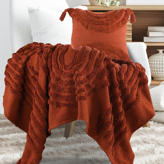 Placed on a chair, the Rust Tufted Throw with Cushion Cover, a brick red throw and cover set you can buy online at Sukham Home, a sustainable furniture, kitchen & dining and home decor store in Kolkata, India