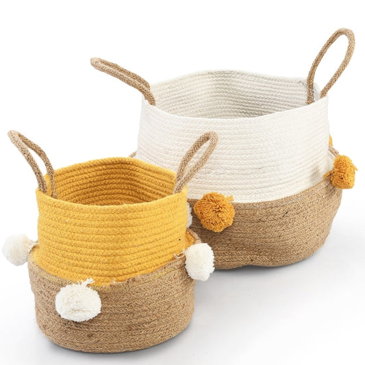 Against a white background, the Playful Pom Pom Basket Set, a set of 2 yellow and white jute & cotton baskets you can buy online at Sukham Home, a sustainable furniture, kitchen & dining and home decor store in Kolkata, India
