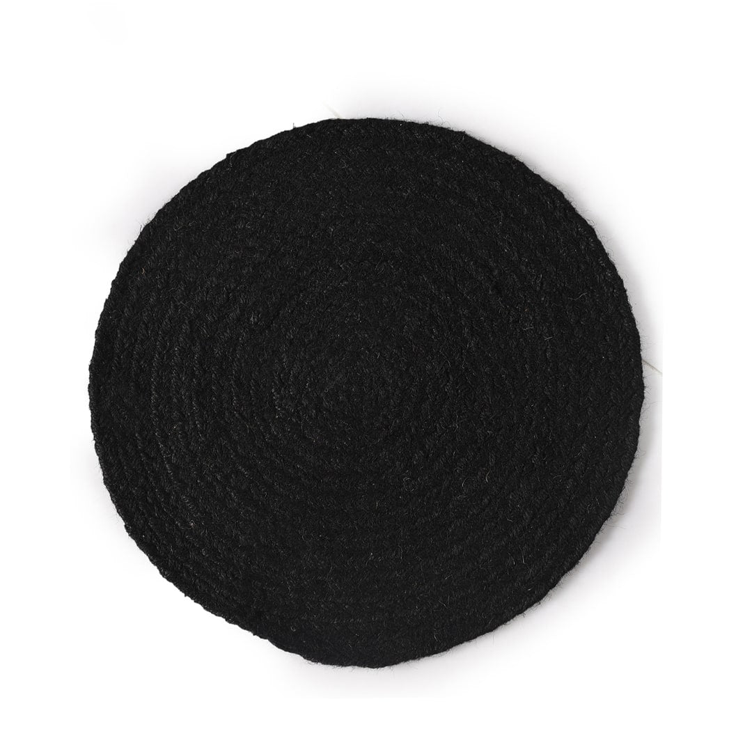 Against a white background, the Black Jute Placemat, a set of 2 or 4 round table mats you can buy online at Sukham Home, a sustainable furniture, kitchen & dining and home decor store in Kolkata, India