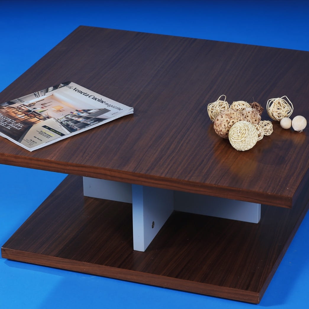Against a blue background, top view of the Walnut Natural Stage Centre Table, a wooden square coffee and centre table you can buy online at Sukham Home, a sustainable furniture, kitchen & dining and home decor store in Kolkata, India
