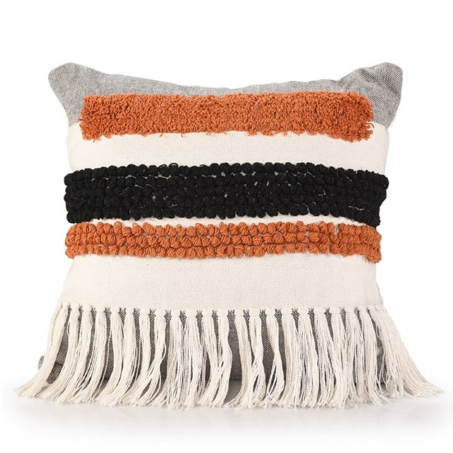 Against a white background, the Tasselled & Tufted Cushion, a square white and orange accent pillow available at Sukham Home, a sustainable furniture, kitchen & dining and home decor store in Kolkata, India