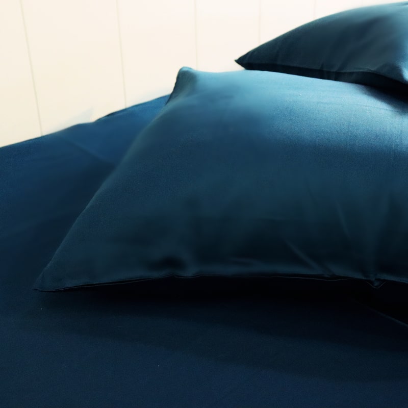 Both pillowcases and bedsheet of the Teal Green Classic Solid Bedsheet, a king size and queen size cotton bedsheet you can buy online at Sukham Home, a sustainable furniture, gardening and home decor store in Kolkata, India