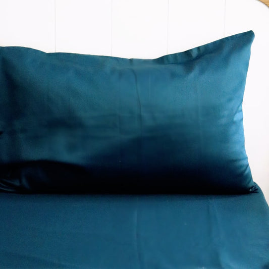 Close of the pillowcase and bedsheet of the Teal Green Classic Solid Bedsheet, a king size and queen size cotton bedsheet you can buy online at Sukham Home, a sustainable furniture, gardening and home decor store in Kolkata, India