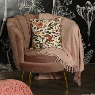 On a pink sofa, the Vibrant Flora Cushion, a square printed floral accent pillow available at Sukham Home, a sustainable furniture, kitchen & dining and home decor store in Kolkata, India