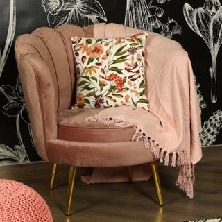 With a pink throw, the Vibrant Flora Cushion, a square printed floral accent pillow available at Sukham Home, a sustainable furniture, kitchen & dining and home decor store in Kolkata, India