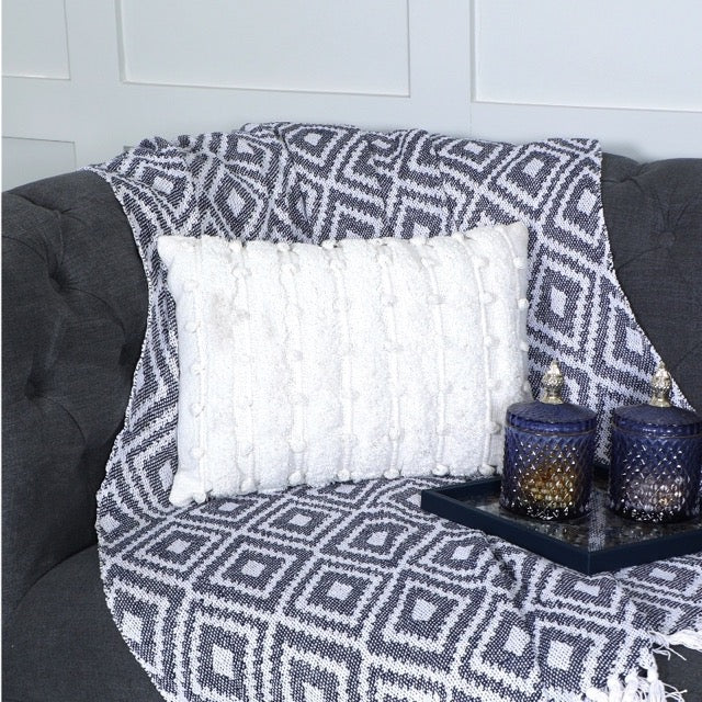 On a sofa, the White Tufted Lumbar Cushion, a rectangle ivory accent pillow available at Sukham Home, a sustainable furniture, kitchen & dining and home decor store in Kolkata, India