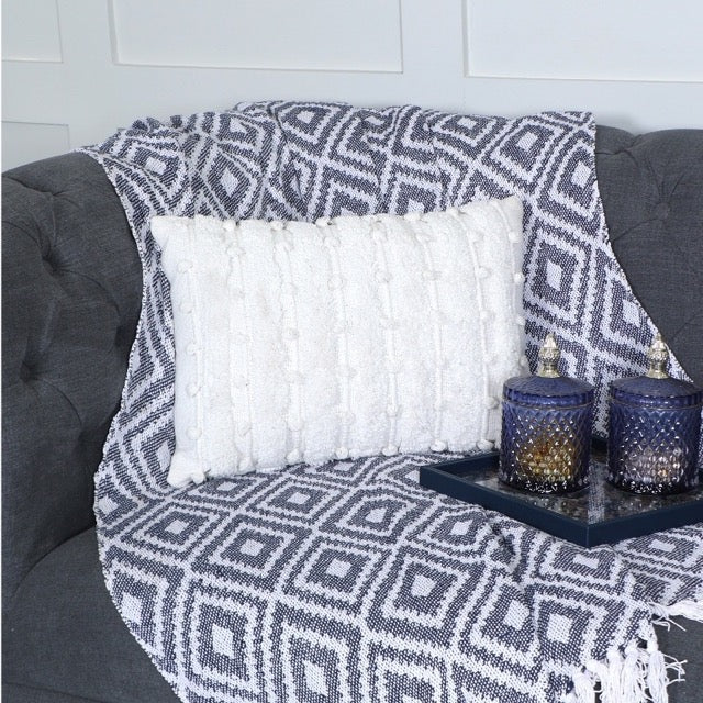 Paired with a throw, the White Tufted Lumbar Cushion, a rectangle ivory accent pillow available at Sukham Home, a sustainable furniture, kitchen & dining and home decor store in Kolkata, India