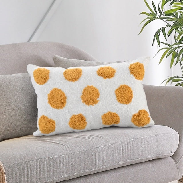 On a sofa, the White Lumbar Cushion with Tufted Yellow Circles, a rectangle ivory and mustard polka-dot accent pillow available at Sukham Home, a sustainable furniture, kitchen & dining and home decor store in Kolkata, India