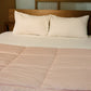 Placed on a bed, the White Sateen Striped Bedsheet, a king and queen size cotton bedsheet you can buy online at Sukham Home, a sustainable furniture, gardening and home decor store in Kolkata, India