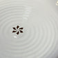 Close up of the gold flakes and ribbed design on the Ivory Ganga Dinner Plate, a pure white and 24-karat gold ceramic plate you can buy online at Sukham Home, a sustainable furniture, gardening and home decor store in Kolkata, India