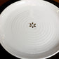 Placed on a black table mat, Ivory Ganga Dinner Plate, a pure white and 24-karat gold ceramic plate you can buy online at Sukham Home, a sustainable furniture, gardening and home decor store in Kolkata, India