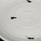 Close up of the ribbed texture and gold flakes on the Ivory Ganga Quarter Plate, a white and 24-karat gold ceramic small plate you can buy online at Sukham Home, a sustainable furniture, gardening and home decor store in Kolkata, India
