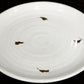 Tilted view of the Ivory Ganga Quarter Plate, a white and 24-karat gold ceramic small plate you can buy online at Sukham Home, a sustainable furniture, gardening and home decor store in Kolkata, India