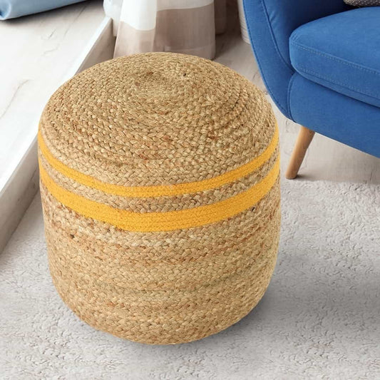 Placed next to a sofa on a carpet, the Jute Pouf with Yellow Accent, a braided and stitched ottoman made from jute & cotton, available at Sukham Home, a sustainable furniture, kitchen & dining and home decor store in Kolkata, India