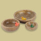 Against a yellow background, the Birds in Paradise Wooden Bowls, a set of 3 solid wood bowls with sculptures you can buy online at Sukham Home, a sustainable furniture, kitchen & dining and home decor store in Kolkata, India